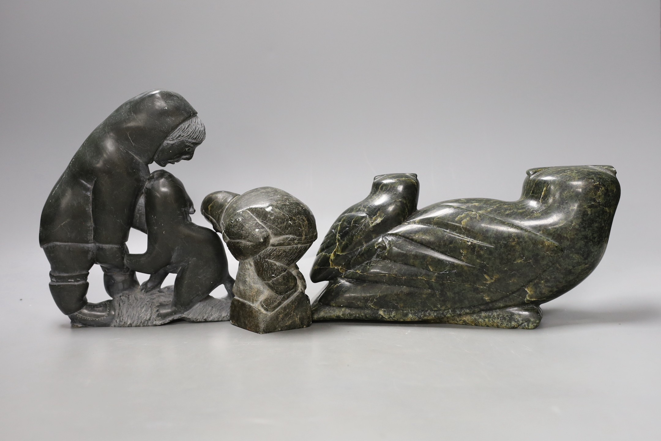 Three 20th century Inuit stone figure carvings, one bearing marine bone eyes - tallest 19cm